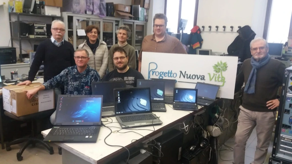 Foto di gruppo volontari Progetto Nuova Vita in laboratorio con PC